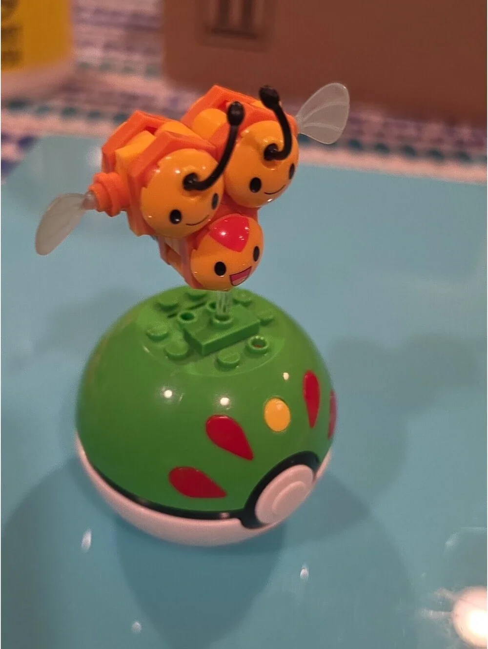 Pokémon Combee Plastic Figure on Green Poké Ball Base, Yellow/Black/Orange